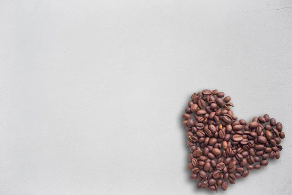 Granos de café en forma de corazón sobre fondo hermoso. Amor. Inscripción. Sobre fondo de madera . — Foto de Stock