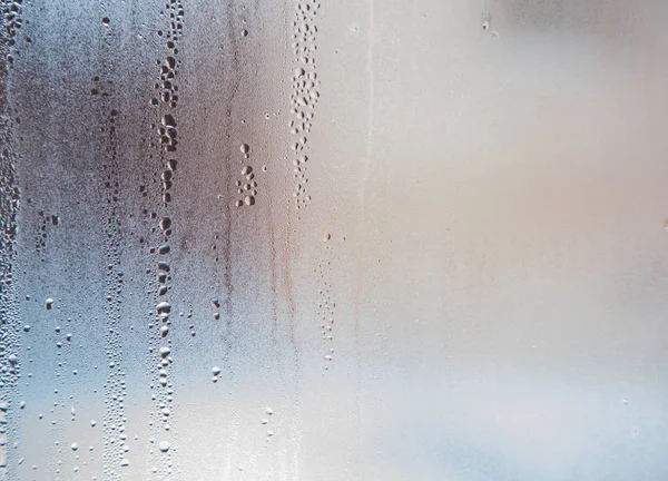 Água e chuva cai sobre o vidro, vista abstrata, gotas de chuva sobre fundo de vidro — Fotografia de Stock