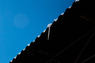 bulutsuz bir günde parlak açık buz buz sarkıtları asmak