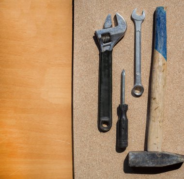 Bazı aletler tahta bir masanın üzerine serpiştin. Ahşap masa üzerinde araç kiti. İş mekaniği için mükemmel. Metin için alan