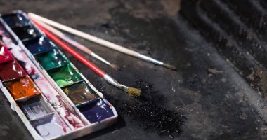 Eski kullanılan suluboya seti ve grunge metal arka plan üzerinde eski fırçalar. Metin için alan