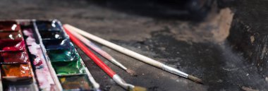 Eski kullanılan suluboya seti ve grunge metal arka plan üzerinde eski fırçalar. Metin için alan