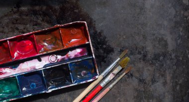 Eski kullanılan suluboya seti ve grunge metal arka plan üzerinde eski fırçalar. Metin için alan