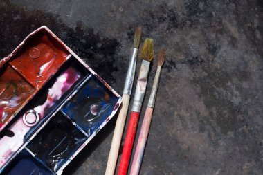 Eski kullanılan suluboya seti ve grunge metal arka plan üzerinde eski fırçalar. Metin için alan