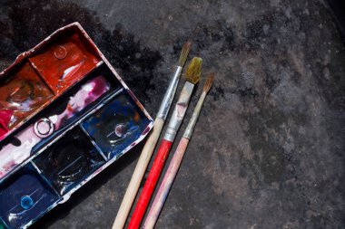 Eski kullanılan suluboya seti ve grunge metal arka plan üzerinde eski fırçalar. Metin için alan