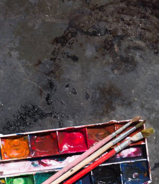 Eski kullanılan suluboya seti ve grunge metal arka plan üzerinde eski fırçalar. Metin için alan