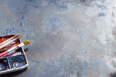 Eski kullanılan suluboya seti ve grunge metal arka plan üzerinde eski fırçalar. Metin için alan