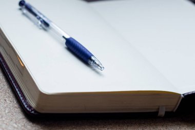 Açık boş dizüstü bilgisayar, cep telefonu, kahve fincanı ve beyaz ahşap masa üzerinde gül buketi yüksek açı görünümü