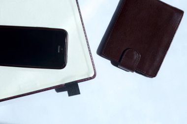 Boş defter, cep telefonu ve beyaz arka plan üzerinde bir cüzdan. . Metin için alan