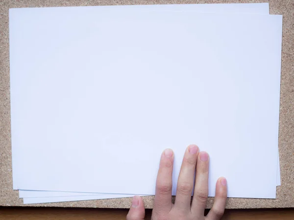Ręce trzymając papier pusty rozmiar A4 dla papieru Letter na drewnianym tle. Z miejscem na tekst — Zdjęcie stockowe