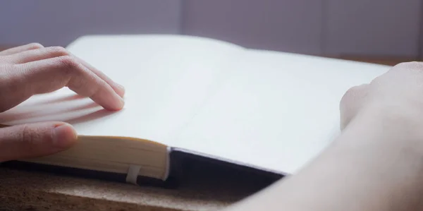 Vrouwelijke handen houden dagboek op het houten bureau. Met ruimte voor tekst — Stockfoto
