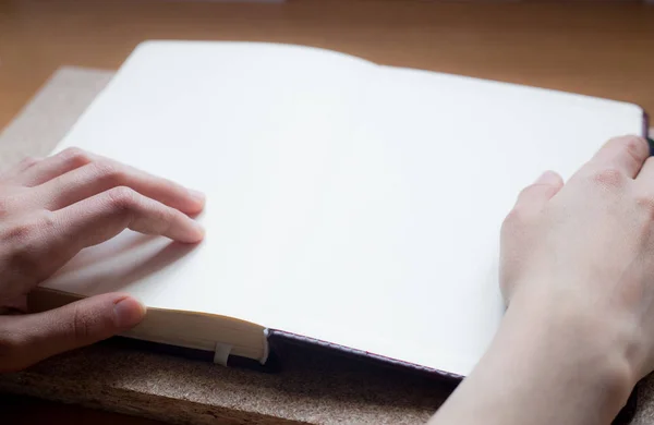 Женские руки держат дневник на деревянном столе. С пробелами для текста — стоковое фото