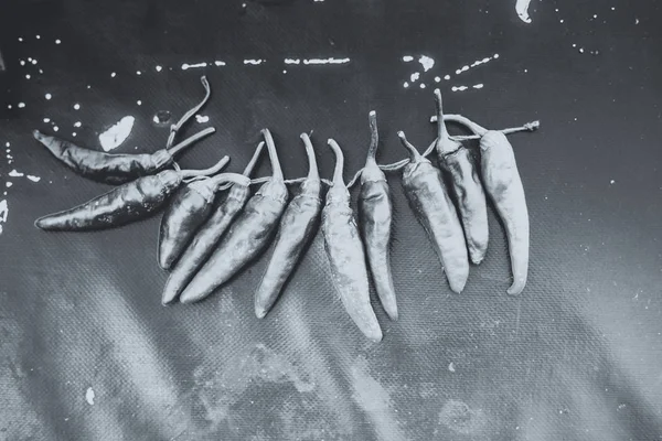 Red hot chili papričky venku. Červené a zelené papriky na pozadí tmavě deska — Stock fotografie