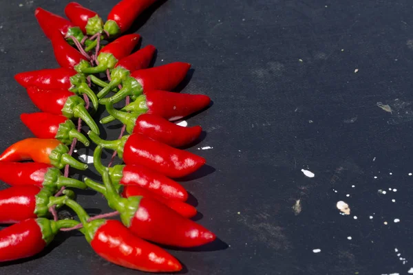 Red hot chili peppers açık havada. Karanlık kurulu arka plan üzerinde kırmızı ve yeşil biber