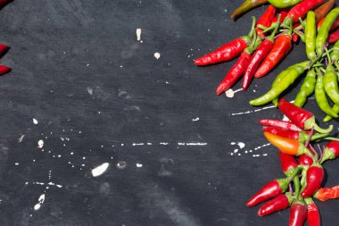 Red hot chili peppers açık havada. Karanlık kurulu arka plan üzerinde kırmızı ve yeşil biber