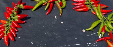 Red hot chili peppers açık havada. Karanlık kurulu arka plan üzerinde kırmızı ve yeşil biber