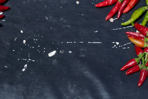 Red hot chili peppers açık havada. Karanlık kurulu arka plan üzerinde kırmızı ve yeşil biber