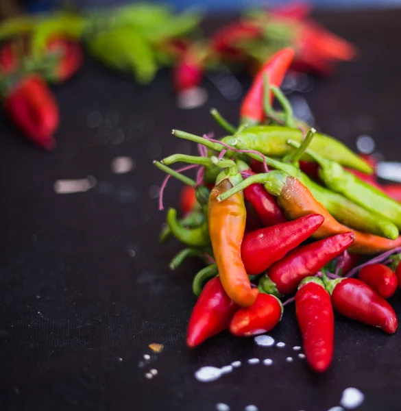 Red hot chili peppers açık havada. Karanlık kurulu arka plan üzerinde kırmızı ve yeşil biber
