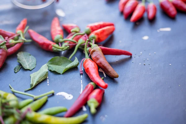 Red hot chili peppers açık havada. Karanlık kurulu arka plan üzerinde kırmızı ve yeşil biber