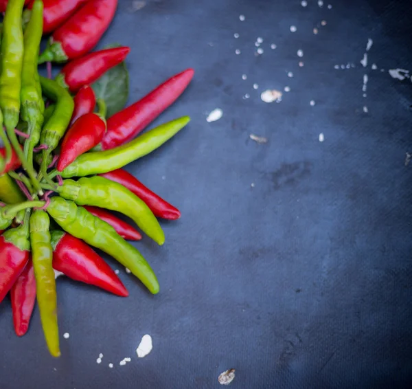 Red hot chili peppers açık havada. Karanlık kurulu arka plan üzerinde kırmızı ve yeşil biber