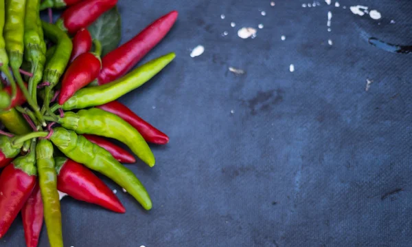 Red hot chili peppers açık havada. Karanlık kurulu arka plan üzerinde kırmızı ve yeşil biber