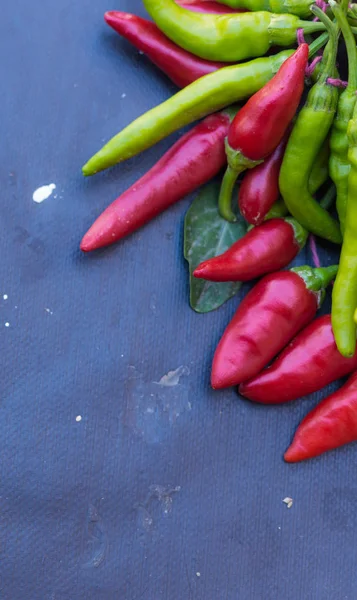 Red hot chili peppers açık havada. Karanlık kurulu arka plan üzerinde kırmızı ve yeşil biber