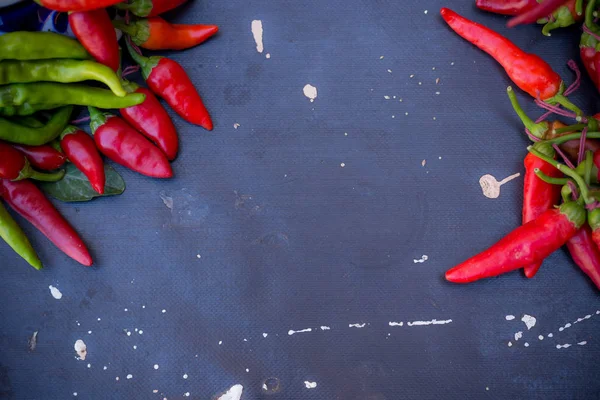 Red hot chili peppers açık havada. Karanlık kurulu arka plan üzerinde kırmızı ve yeşil biber