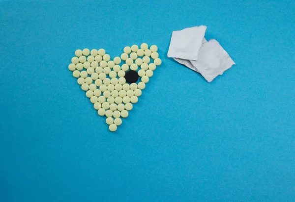 Pastillas amarillas en forma de corazón con la tableta grande negro — Foto de Stock