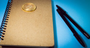 Ahşap not defteri, Bitcoin para ve iki siyah kalem