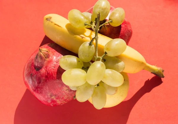 Ovanifrån av uppsättning färska frukter: gyllene äpple, banan, granatäpple och druvor — Stockfoto