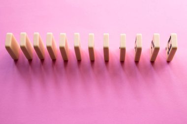 Pembe bir arka plan üzerinde Domino satır. Düz yatıyordu