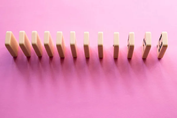 Fila de dominó sobre fondo rosa. Puesta plana — Foto de stock gratis
