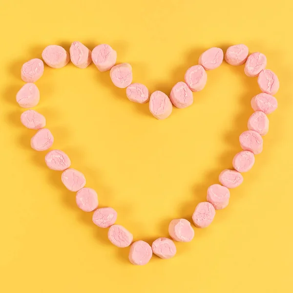 Marshmallow-Bonbons in Herzform platziert. Valentinstag und Liebeskonzept auf gelbem Hintergrund — Stockfoto