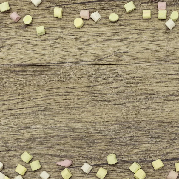 Cadre de vacances. Bonbons sucrés bordure guimauve Décoration colorée sur fond en bois. Espace de copie. Vue du dessus . — Photo