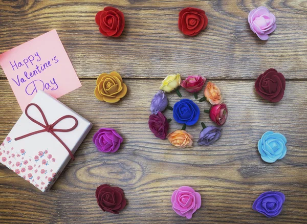 Koncepcja Walentynki. Pudełko z tekstem na naklejki: szczęśliwy Valentine's day. Grupa kwiaty na podłoże drewniane. — Zdjęcie stockowe