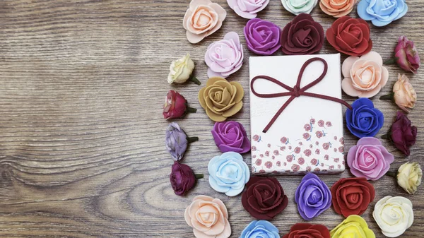 stock image Symbol of Valentine's day. Gift box with group of roses over wooden table. Top view.