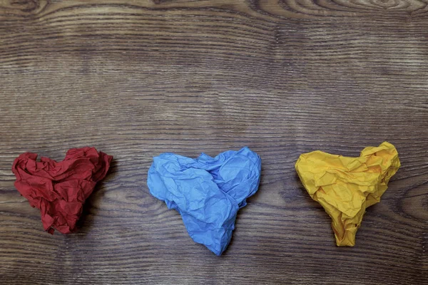 Três coloridos em forma de coração crumpled papéis na mesa de madeira. Do Valentine. Dia dos namorados. Conceito 14 de Fevereiro . — Fotografia de Stock