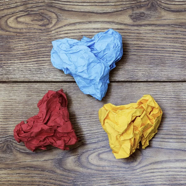 三五颜六色的心形皱巴巴的纸在木桌上。情人节情人节。2月14日概念. — 图库照片