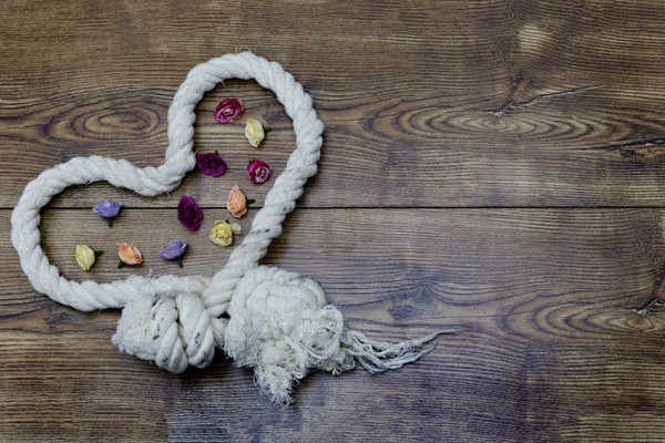 Cuerda en forma de corazón y flores en madera. decoración del día de San Valentín . — Foto de Stock