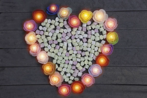 Słodkie pianki w kształcie serca zdobią kwiaty na tle drewna. koncepcja dzień Valentine. — Zdjęcie stockowe