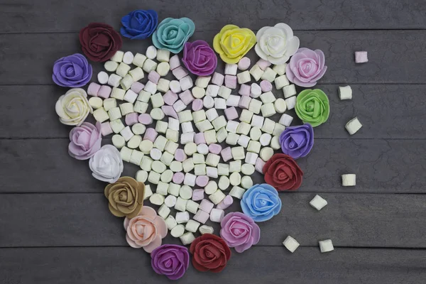 Słodkie pianki w kształcie serca zdobią kwiaty na tle drewna. koncepcja dzień Valentine. — Zdjęcie stockowe