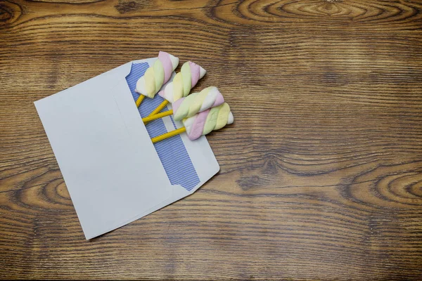 Färgglada marshmallows i kuvert trä studio bakgrunden — Stockfoto