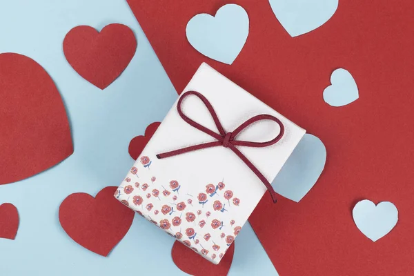 White box and paper hearts on devided colour background, Valentine — Stock Photo, Image