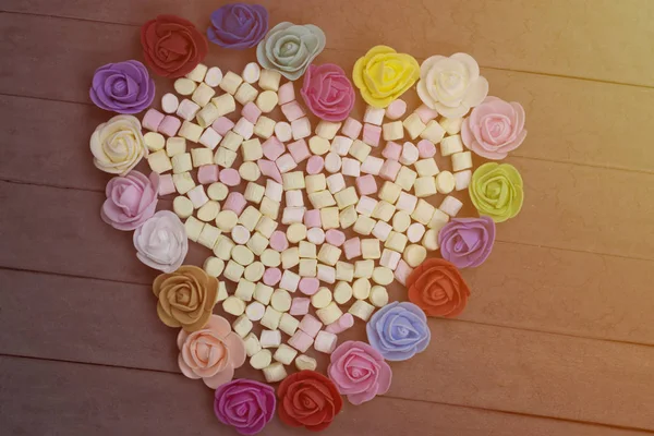 ハートの甘いマシュマロは、ウッドの背景に花で飾られました。バレンタインの日の概念. — ストック写真