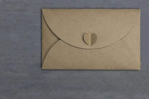 Envelop gemaakt van bruin gerecycleerd papier op hout achtergrond — Stockfoto