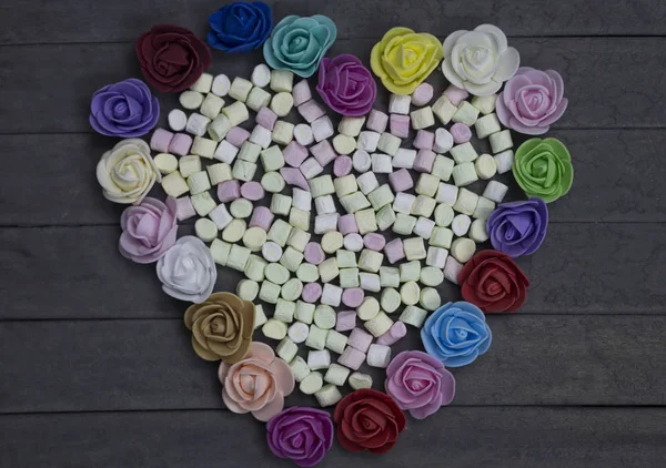 Süße Marshmallows in Herzform, verziert mit Blumen auf Holzgrund. Valentinstag-Konzept. — Stockfoto