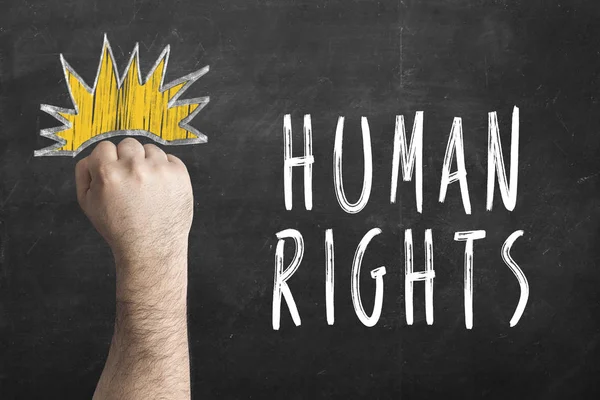 Fist and inscription Human rights on chalkboard. International Human Rights Day. — Stock Photo, Image