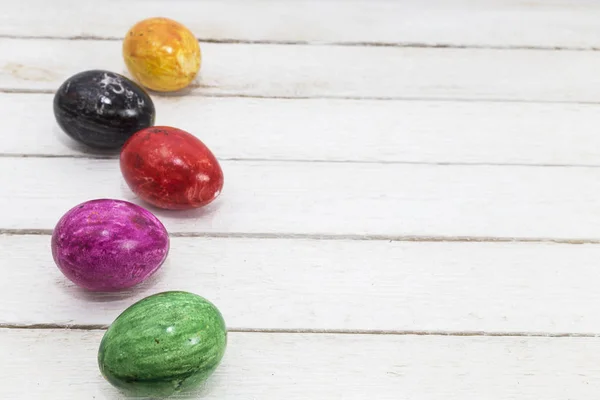 Felicitări de Paște cu ouă colorate verde, galben, violet și roșu pe fundal vechi din lemn . — Fotografie, imagine de stoc