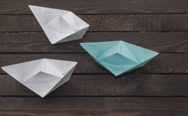 Beyazlar, koyu ahşap arka plan üzerinde lider liderlik kavramı, mavi lider tekne