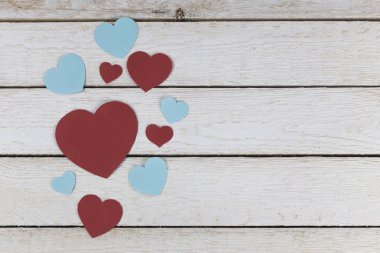 Grup mavi ve kırmızı kağıt kalplerin Beyaz ahşap zemin üzerine koydu.